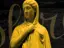 Golden statue of a serene, veiled woman against a dark, ancient amphitheater background with cursive text overlay.