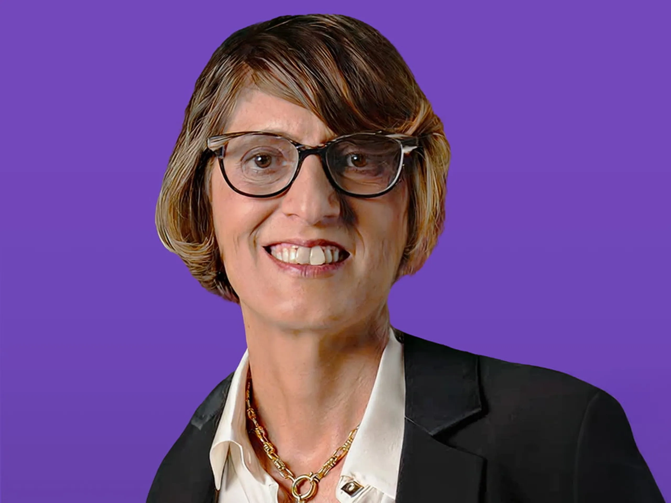 Persona sorridente con capelli corti e occhiali, che indossa un blazer nero e una camicia bianca. Lo sfondo è viola uniforme.